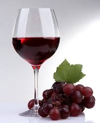 Rotwein im Glas auf Holztisch